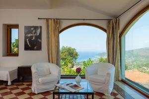 ein Wohnzimmer mit zwei Stühlen und einem Glastisch in der Unterkunft Natursteinvilla mit Meerblick , 2km über dem Meer-Cilentissimo in Santa Maria di Castellabate