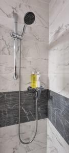 a shower with a shower head in a bathroom at Heart of Inverness-city apartment in Inverness