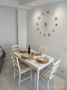 トロクス・コスタにあるEstudioの白いテーブル(椅子付)、壁掛け時計