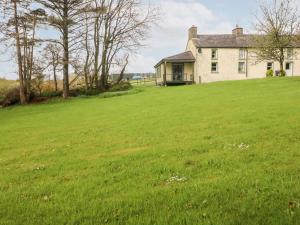 a house on a hill with a large green field at The West Wing 