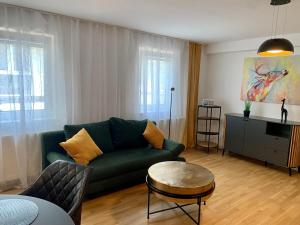 uma sala de estar com um sofá verde e uma mesa em Ruhiges Apartment mit Terrasse im Zentrum St. Pölten em Sankt Pölten