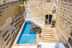 a swimming pool in a building with a staircase next to it at Tal-Andar Farmhouse in Kerċem