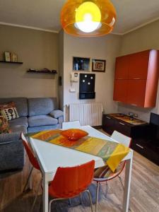 sala de estar con mesa, sillas y sofá en Mysa Properties -Luminoso bilocale, Cormano, en Cormano