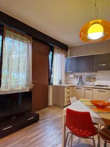 kuchnia ze stołem i czerwonymi krzesłami w pokoju w obiekcie Mysa Properties -Luminoso bilocale, Cormano w mieście Cormano