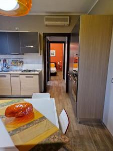 uma cozinha com uma mesa e uma cozinha com um fogão em Mysa Properties -Luminoso bilocale, Cormano em Cormano
