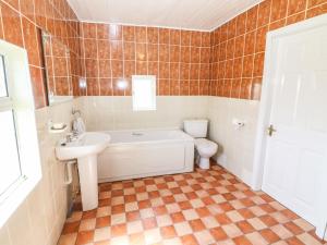 a bathroom with a tub and a toilet and a sink at Forest View in Teeranearagh +33 photos