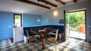 ein Esszimmer mit blauen Wänden sowie einem Tisch und Stühlen in der Unterkunft Natursteinvilla mit Meerblick , 2km über dem Meer-Cilentissimo in Santa Maria di Castellabate