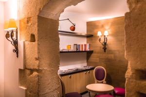 a room with a counter and a table and chairs at Hotel Marais Grands Boulevards in Paris