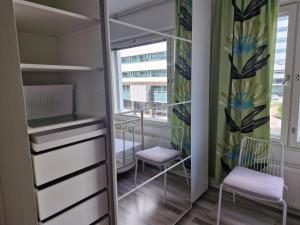 ein Ankleidezimmer mit 2 Stühlen und einem Spiegel in der Unterkunft Bright, big apartment with own sauna & balcony in Helsinki
