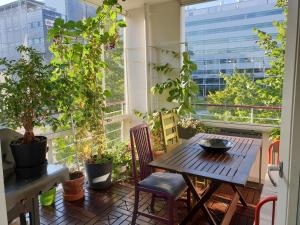 einen Balkon mit einem Tisch, Stühlen und Pflanzen in der Unterkunft Bright, big apartment with own sauna & balcony in Helsinki
