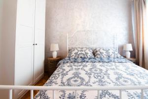 a bedroom with a blue and white bed with two lamps at Apartman Karla in Sinj