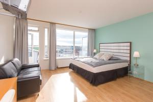 a bedroom with a bed and a chair and windows at Hotel Keilir by Reykjavik Keflavik Airport in Keflavík