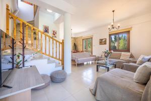 a living room filled with furniture and a staircase at The River House in Trimiklini