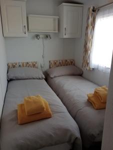 2 camas individuais num pequeno quarto com uma janela. em Lapwing Lodge em Louth