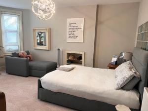 a bedroom with a bed and a couch and a chandelier at Boho Beach House - Beach location in Bournemouth