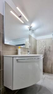 La salle de bains est pourvue d'un lavabo blanc et d'un miroir. dans l'établissement Guest Holiday Mandra 12 e 13, à Reggio d'Émilie