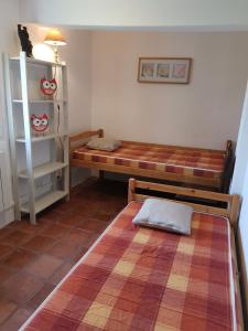- une chambre avec 2 lits et une étagère dans l'établissement Gîte familial de charme entier en Gascogne, à Marseillan