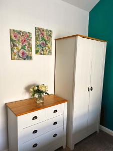 a bedroom with a dresser and a white cabinet at Bangor Central Apartments in Bangor