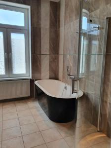 een grote badkamer met een bad en een douche bij Gamleby Hotell in Gamleby