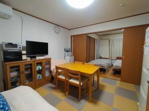 a room with a table and a television and a bedroom at At Home N23 in Sapporo