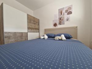a bedroom with a blue bed with two stuffed animals on it at Apartman REA 1 in Pirot
