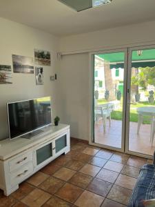 a living room with a television and a patio at Bungalow Carmen in San Bartolomé
