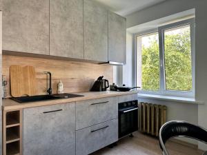 cocina con fregadero, fogones y ventana en Riga Mezaparks apartment + private parking en Riga