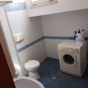 een badkamer met een toilet en een wasmachine bij Casa SOAVE in Sperlonga