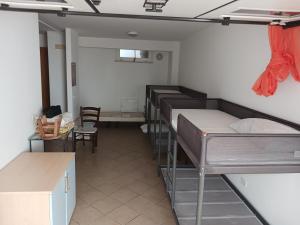 een kamer met meerdere stapelbedden en een tafel en stoelen bij Casa SOAVE in Sperlonga