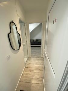 a hallway with a mirror on the wall at Appartement Cosy in Le Bourget