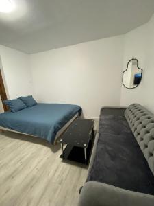 a room with two beds and a couch and a mirror at Appartement Cosy in Le Bourget