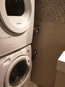 een wasmachine naast een toilet in een badkamer bij Bright, big apartment with own sauna & balcony in Helsinki