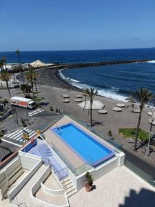 a large swimming pool next to a beach at Coco & Palma with Sea Views in Puerto de la Cruz