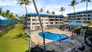 an aerial view of a resort with a pool and palm trees at Kona Reef A32 in Kailua-Kona