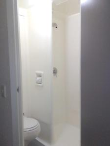 a white bathroom with a toilet and a shower at SUN1 Kimberley in Kimberley