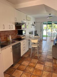 a kitchen with white cabinets and a table and chairs at Bungalow Carmen in San Bartolomé