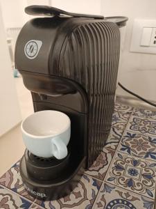 eine schwarze Kaffeemaschine mit einer Tasse auf dem Tisch in der Unterkunft Interno 3 - vicino al mare e pista ciclabile, centro zona Foce in Sanremo
