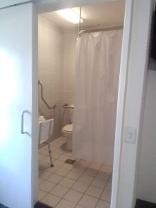 a bathroom with a toilet and a shower with a curtain at SUN1 Kimberley in Kimberley