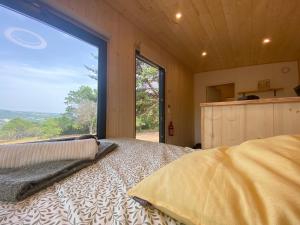a bedroom with a bed and a large window at La Bastide Provençale - Terre d'Ocre & de Lavande in Viens