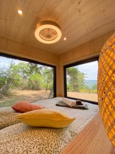 a room with two large windows and a bed with pillows at La Bastide Provençale - Terre d'Ocre & de Lavande in Viens