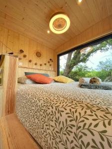 a bedroom with a large bed with a large window at La Bastide Provençale - Terre d'Ocre & de Lavande in Viens