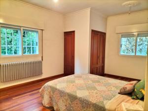 拉科魯尼亞的住宿－Oasis en Ponte San Lázaro，一间卧室设有一张床和两个窗户。