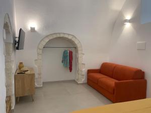 una sala de estar con un sofá naranja y un arco en B&B LA FONTANA, en Mattinata