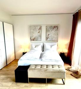 Schlafzimmer mit einem großen Bett mit einer Bank in der Unterkunft Villa Maria Boutique Apartment St Pauls in Appiano sulla Strada del Vino