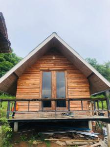 a log cabin with a window on a platform at Pai Kitchen Hub Hostel in Pai