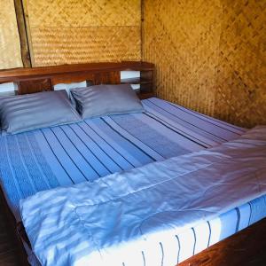 a bedroom with a bed with blue sheets at Pai Kitchen Hub Hostel in Pai