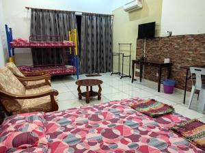 um quarto com uma cama, cadeiras e uma mesa em Taiping Centre Point Suite em Taiping