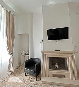 a living room with a fireplace with a television and a chair at Pit stop Ciampino Station in Ciampino