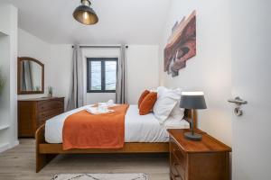 a bedroom with a bed and a table with a lamp at Basalt Dwelling I by Madeira Sun Travel in São Vicente