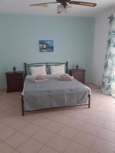 Villa Calli في ماليا: غرفة نوم بسرير ومروحة سقف